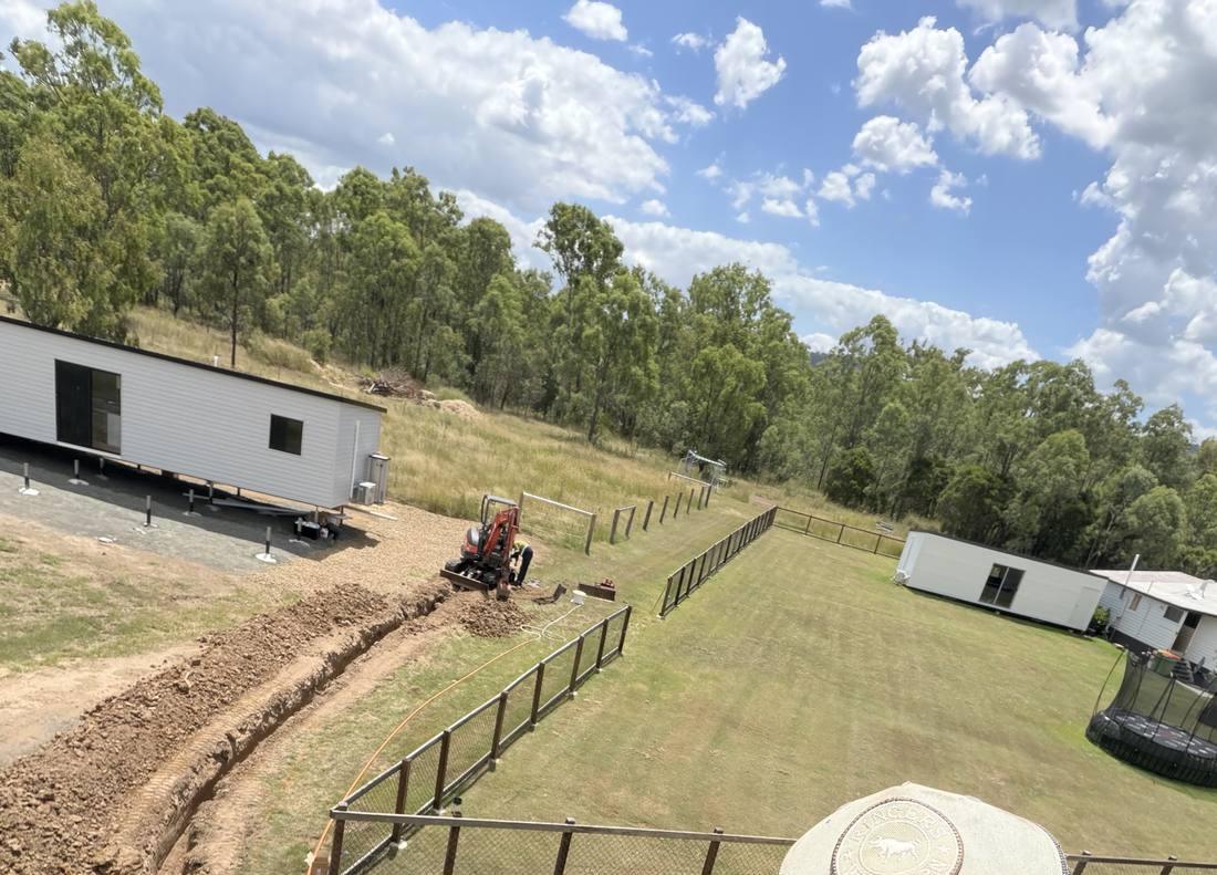 Trench dug across a rural block with conduit run to a second dwelling