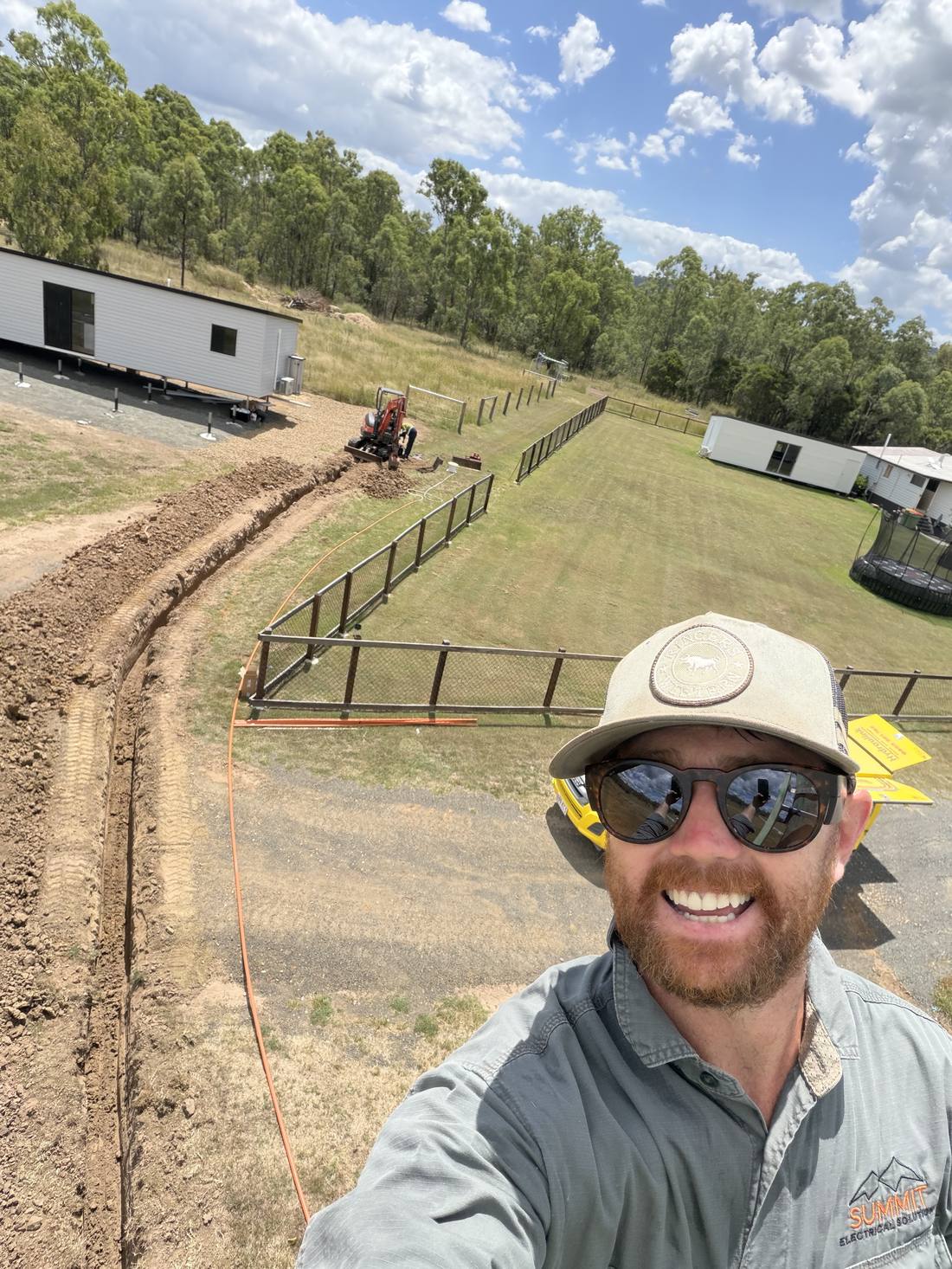 Taylor on site at a rural property beside a freshly dug cable trench