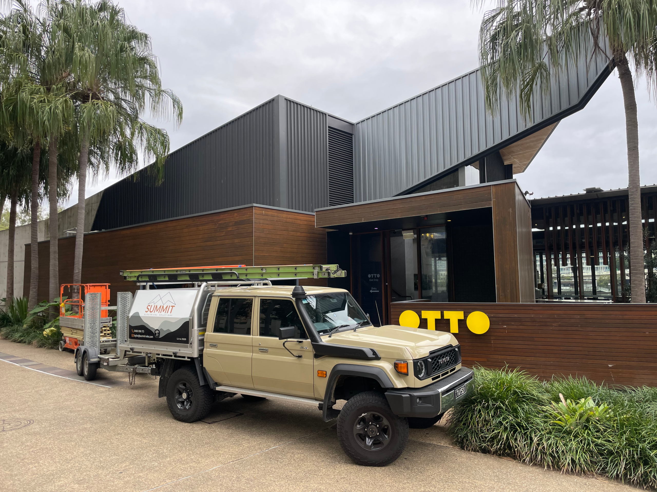 Summit Electrical ute and trailer parked outside a riverside commercial fit-out