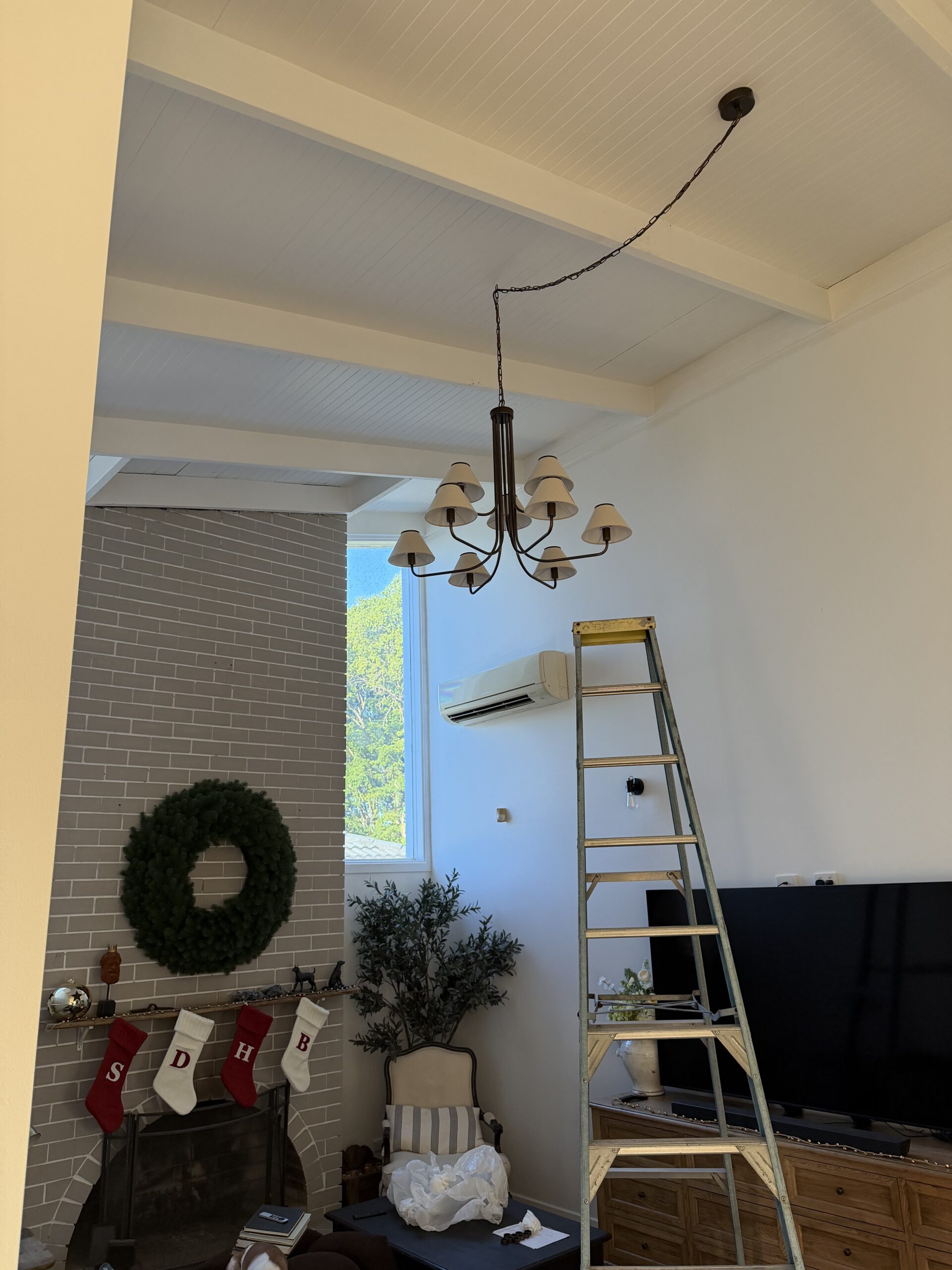 Nine-arm chandelier hung from a raked timber-lined ceiling